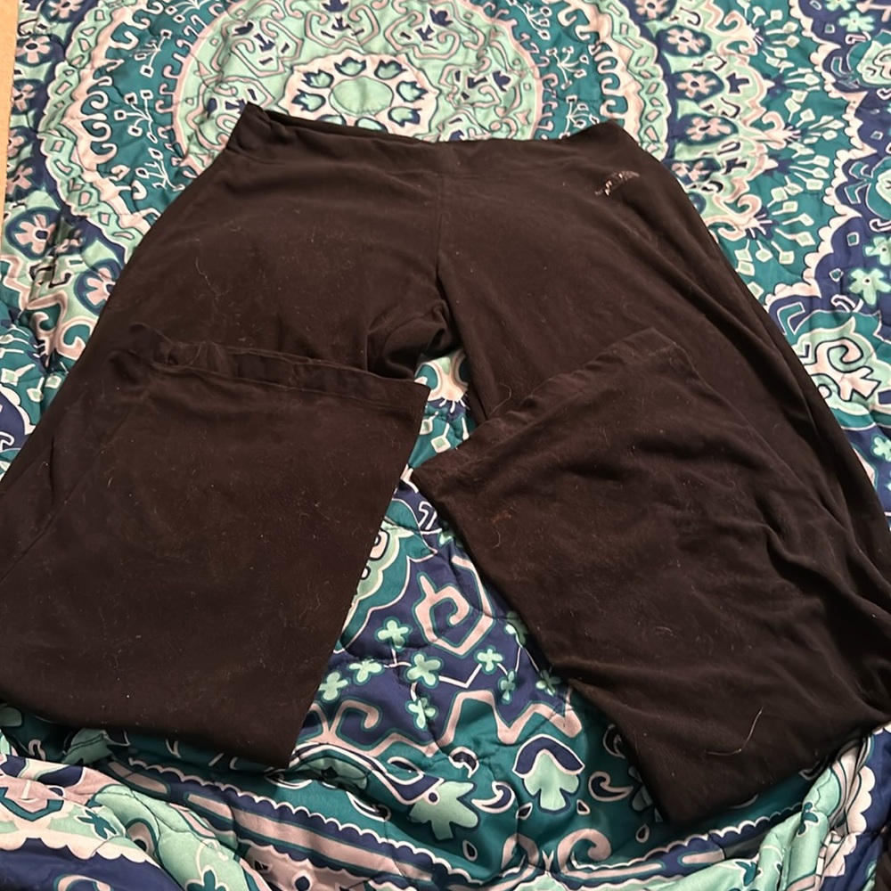 North Face flare leggings. North face is faded. Has a little bleach stain on leg